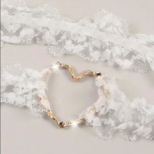 Garter, weddings, white lace w/ golden metal heart. Approx 91/4” diam. NIP